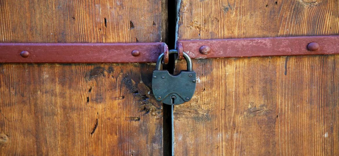 The padlock on an old wooden door