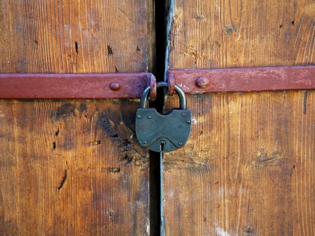 The padlock on an old wooden door