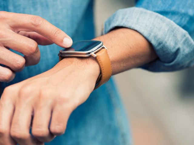 Man in the street using his smart-watch app. Urban background