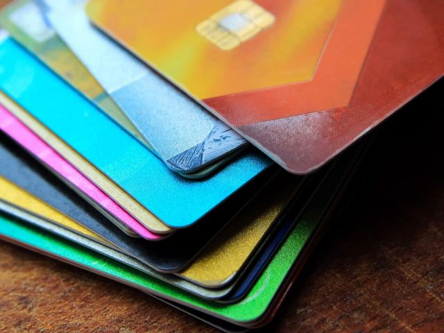 Big stack of bright credit cards on a wooden background